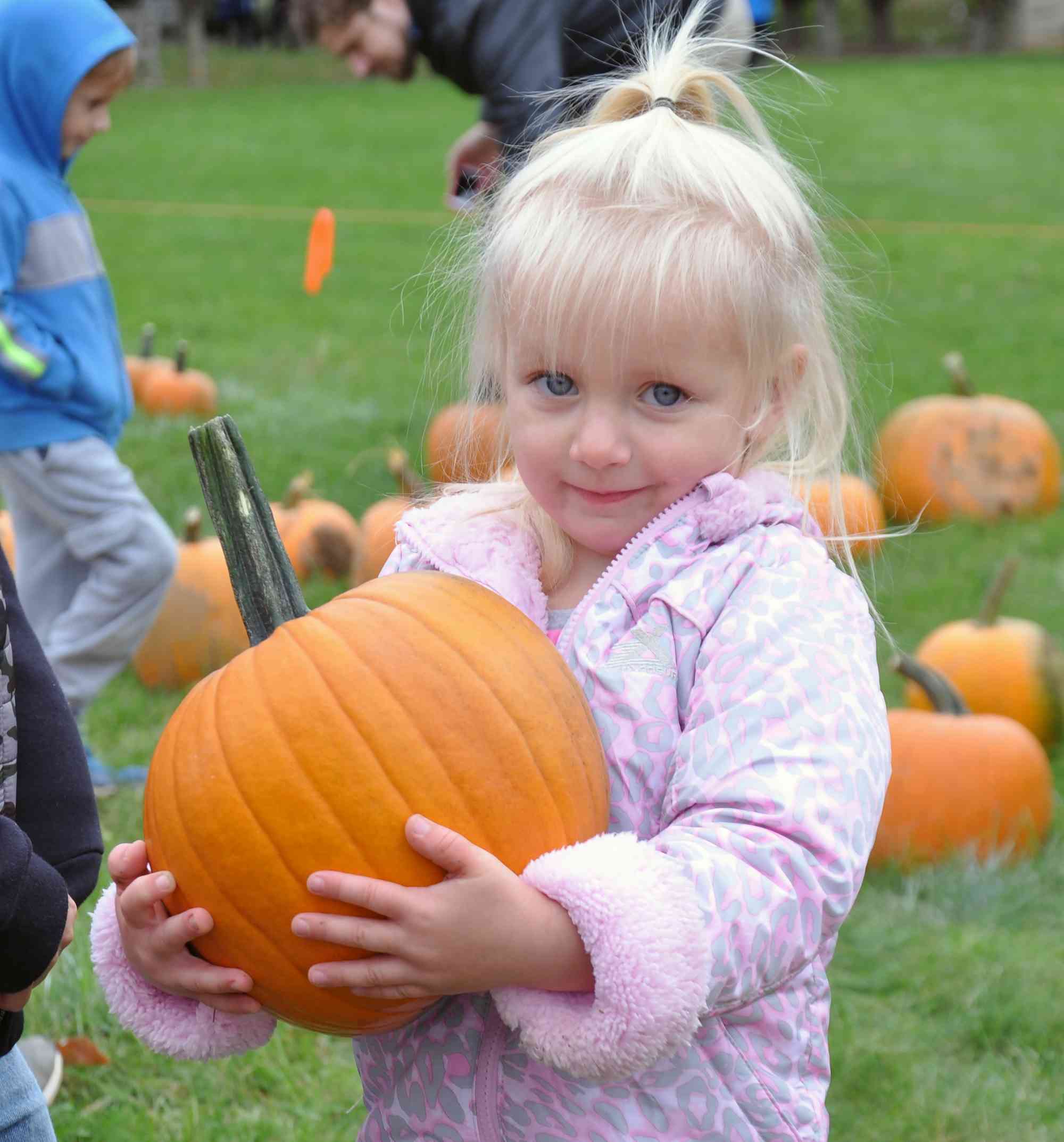 Blonde girl holding largish pumpkin