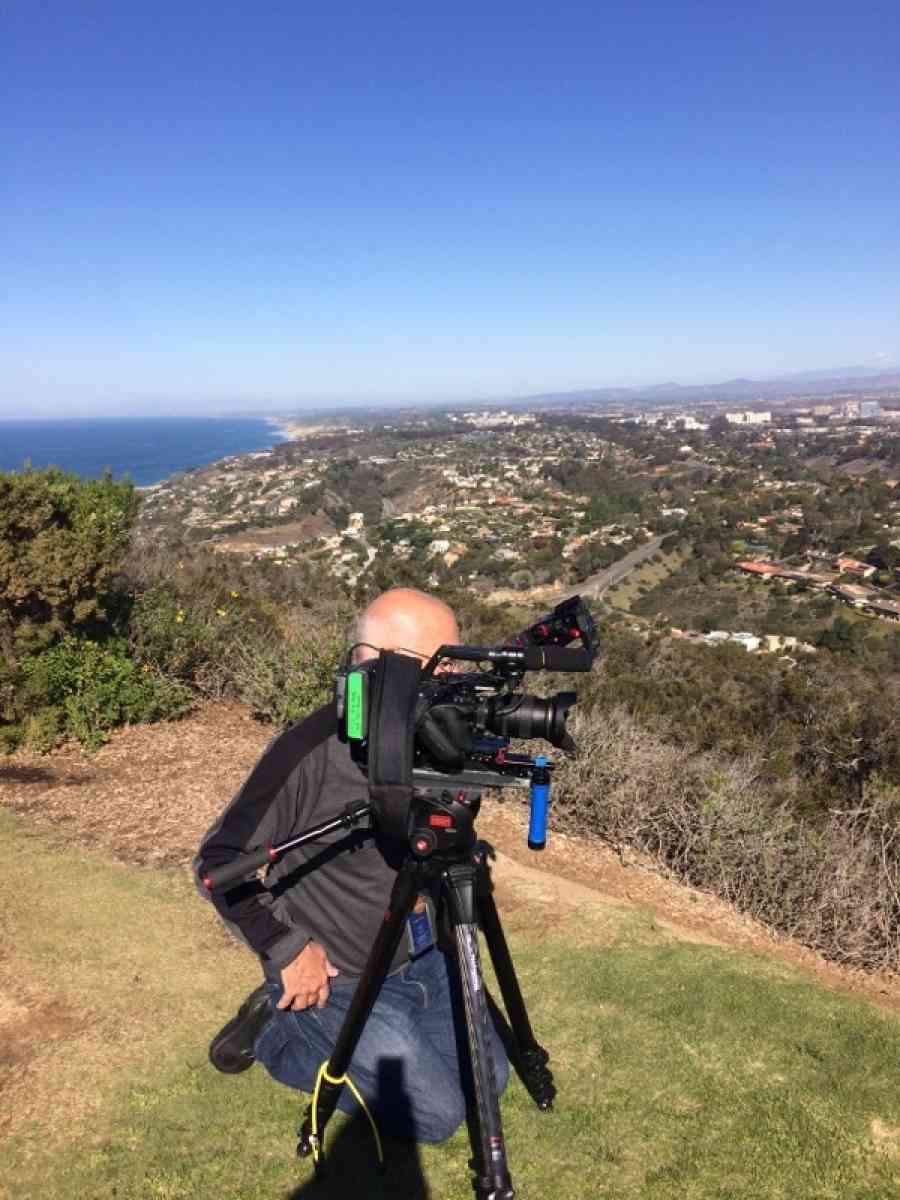 Greg Guise on a hillside near San Diego shooting an immigration story